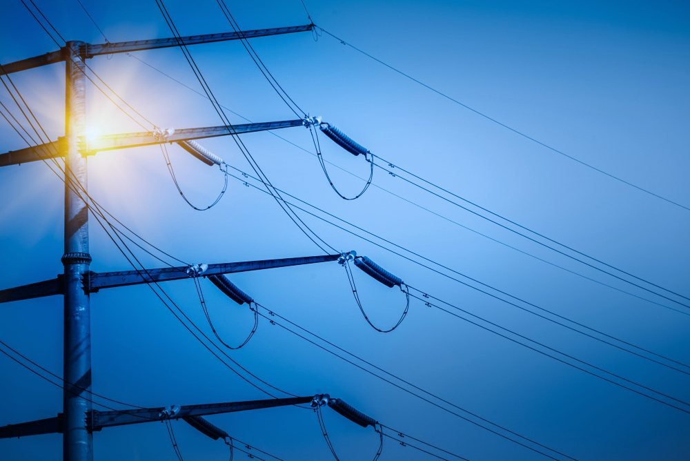 Power distribution lines against a blue sky